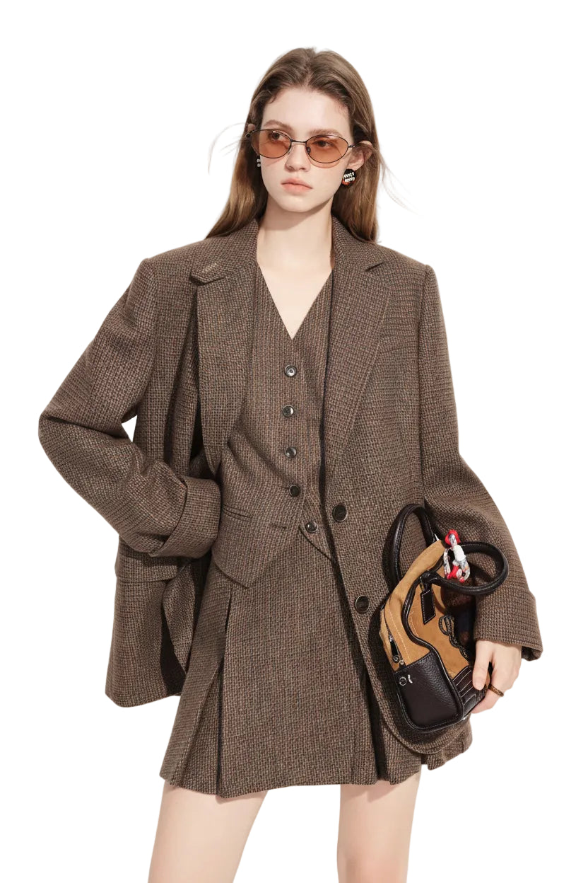 Woman wearing a brown checkered suit holding a handbag on a white background with 'fsle' branding.