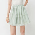 A model wearing a light mint green tiered tulle mini skirt with an elastic waistband, paired with a white top against a plain white background. The brand logo 'fsle' is visible in the top left corner.