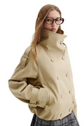 A model wearing a beige double-breasted trench jacket with a high collar and large buttons, paired with a plaid skirt. The brand logo 'fsle' is visible in the top left corner.