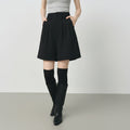 Person wearing a black skirt with a plain background